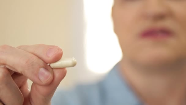 Femme tenant la capsule d'huile de poisson à la main. Capsules d'huile de poisson comme complément alimentaire contenant des oméga-3 et la vitamine a est élevée pour les soins de santé. — Video