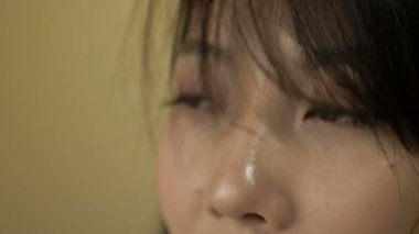 The upper part of the face of a young Korean woman. Thoughtful look. The wind blows her hair a little.