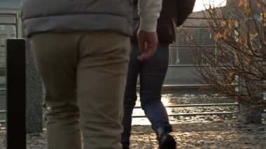 Adam ve kız nehrin ve şehrin manzarasına hayran olmak için baraj kenarındaki metal korkuluklara yaklaştı. Arka plan.