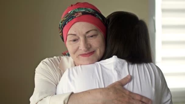 Mujer joven abraza a su madre enferma después de la quimioterapia. Amor, cuidado y apoyo en la familia de un paciente de cáncer. — Vídeos de Stock
