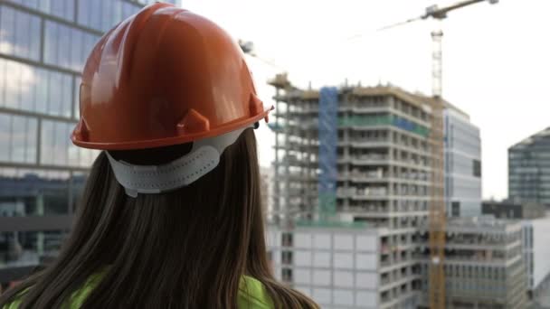 Construtora feminina em um canteiro de obras supervisiona o progresso dos trabalhos de construção. — Vídeo de Stock