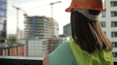 Female builder at a construction site oversees the progress of construction work.