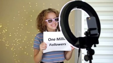 Neşeli kız blogcu kamerada 500K 'lık bir FOLLOWERS posteri gösteriyor. Gençler başarılarını sergiliyor, abone sayısının artması. HD.