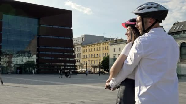 Junger Mann Fährt Mit Freundin Auf Elektroroller Auf Dem Stadtplatz — Stockvideo