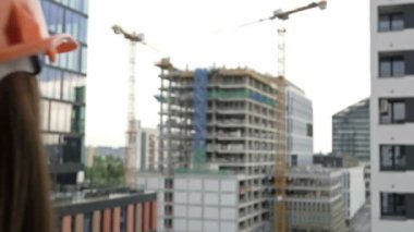 Female builder at a construction site oversees the progress of construction work. HD.