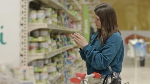 Молодой Клиент Выбирает Необходимые Продукты Возле Полок Детским Питанием Супермаркете — стоковое видео