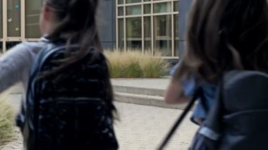 Back to school. A group of elementary school students cheerfully rush to a lesson at school. Latecomers. HD.