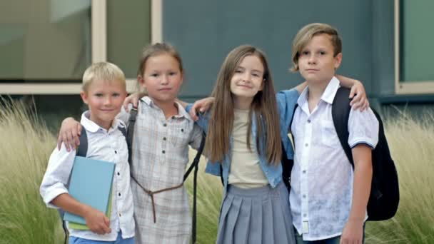Four Friends Elementary School Students Stand Embrace Schoolyard Classmates School — Vídeo de stock
