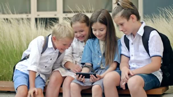 Group Elementary School Students Sit Bench Schoolyard Children Interest Look — Αρχείο Βίντεο