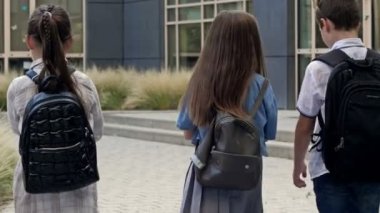 Group of elementary school students rush to a lesson to school. Back to school. 4K.