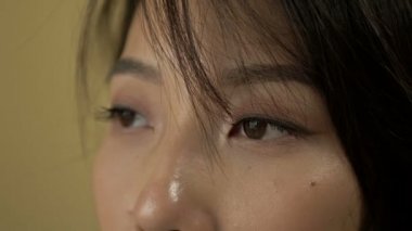 The upper part of the face of a young Korean woman. Thoughtful look. The wind blows her hair a little. HD.