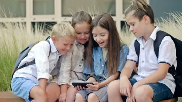 Group Elementary School Students Sit Bench Schoolyard Children Interest Look — Vídeos de Stock