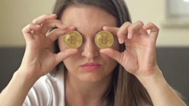 Gözlerini altın paralarla kaplayan neşeli bir kadının portresi. HD.