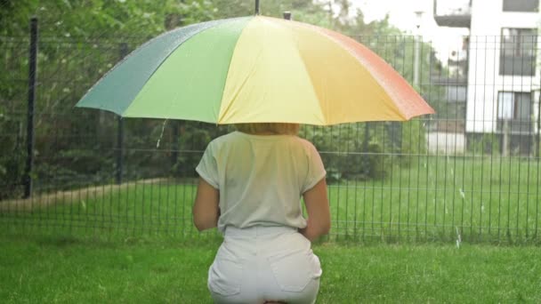 Donna Seduta Sotto Ombrello Luminoso Durante Pioggia Vista Posteriore — Video Stock