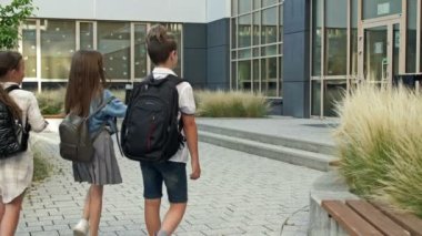 Group of elementary school students rush to a lesson to school. Back to school. 4K.