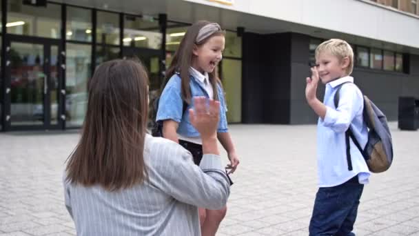 Mama Bringt Die Kinder Zur Schule Die Frau Winkt Zum — Stockvideo