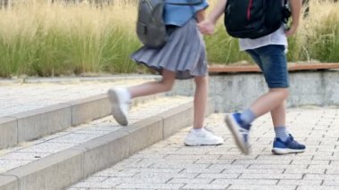 Legs of elementary school students jumping up the stairs in the school yard. 4K.