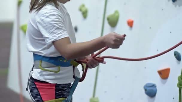 Kleine Klettermädchen Binden Einen Sicherheitsknoten Bevor Sie Die Trainingswand Erklimmen — Stockvideo