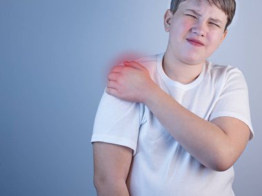 Omuz ağrısı çeken genç bir adam. Hastalık kavramı. Omzunda ağrı, kas ağrısı. Omzunda ağrı var. Hastalığın nedeni gerginlik, stres ya da yaralanma. Boşluğu Kopyala