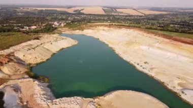 Kum ocağı. Turkuaz lagün ve yüzey mayınları açıkta kalmış renkli mineraller, çukurun dibinde ekipmanlar..