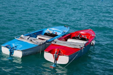 Old two boats, red and blue boats on lake. Clean water