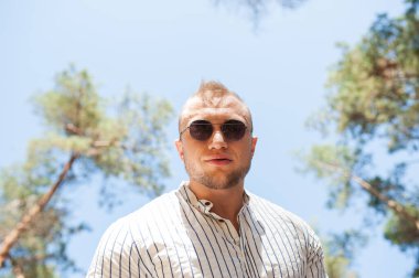 Neşeli adamın fotoğrafı boş görünüyor. Açık havada güneş gözlüğü takıyor. Tatil 