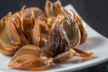 Siyah sarımsak taze ve lezzetli sarımsak pişirerek biter..