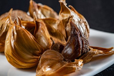 Siyah sarımsak taze ve lezzetli sarımsak pişirerek biter..