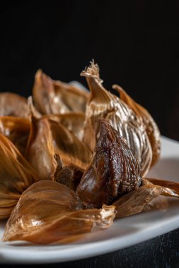 Siyah sarımsak taze ve lezzetli sarımsak pişirerek biter..