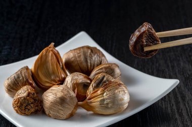 Siyah sarımsak taze ve lezzetli sarımsak pişirerek biter..