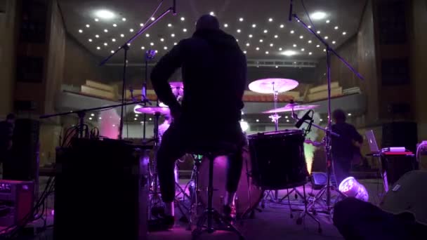 Zadní pohled bubeníka hrajícího na bicí na soundcheck ve velkém koncertním sále — Stock video