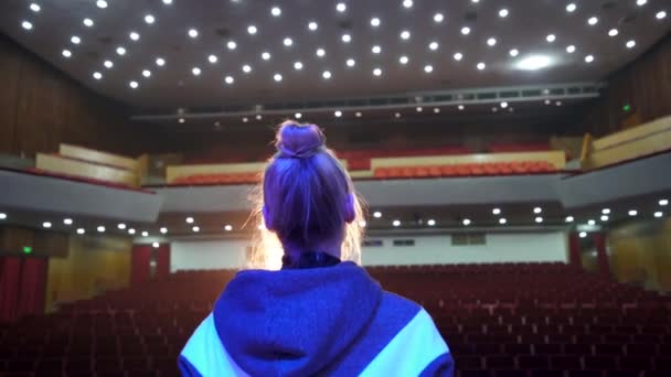Vista trasera de la cantante femenina en el gran escenario de la sala de conciertos con auditorio vacío — Vídeos de Stock