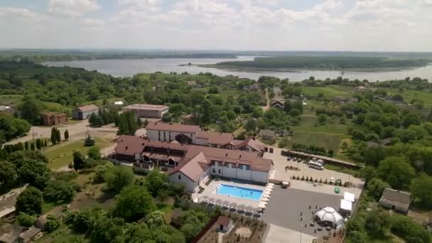 Vista aérea de un pequeño hotel con piscina azul y diseño paisajístico — Vídeo de stock