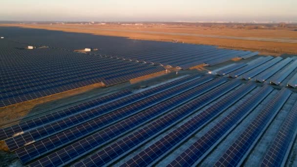 Vista aérea de drones de grandes paneles solares en una granja solar al atardecer a principios de invierno. Centrales eléctricas de células solares — Vídeo de stock