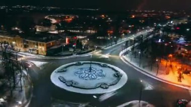 Küçük Avrupa şehrinde yuvarlak arabalı yuvarlak kavşak yolunun 4k hava manzaralı gece zaman çizelgesi