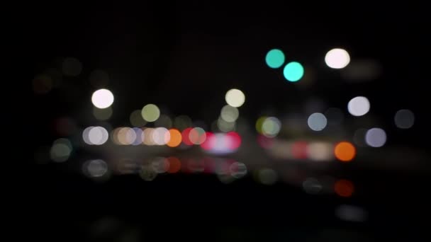 Bokeh de carros e semáforos à noite. Bokeh de pequeno tráfego noturno europeu da cidade. Brilho bokeh colorido redondo das luzes do carro no engarrafamento na rua da cidade — Vídeo de Stock