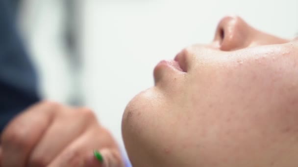 Conceito de bigode feminino de barbear. Close up tiro de médico raspas femsle paciente rosto antes de lazer depilação — Vídeo de Stock