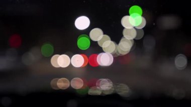 Geceleri araba ve trafik ışıklarıyla dolu bir Bokeh. Küçük Avrupa Şehir Gece Trafiği Bokeh 'i. Şehir caddesinde trafik sıkışıklığında araba ışıklarından yuvarlak renkli bokeh parlıyor