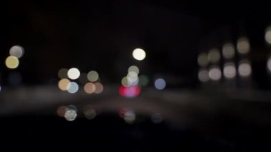 Geceleri araba ve trafik ışıklarıyla dolu bir Bokeh. Küçük Avrupa Şehir Gece Trafiği Bokeh 'i. Şehir caddesinde trafik sıkışıklığında araba ışıklarından yuvarlak renkli bokeh parlıyor