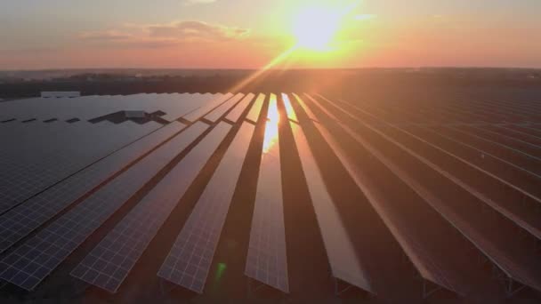 Letecký bezpilotní letoun se za oblačného letního večera dívá na velké solární panely na sluneční farmě. Solární elektrárny, zelená tráva. Video - záběry 4k. — Stock video