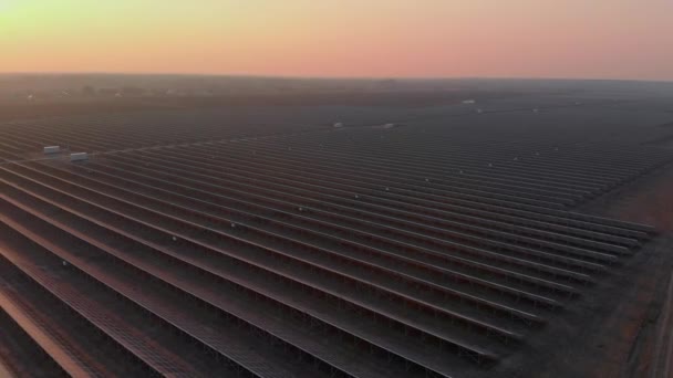 Aerial drone view of large solar panels at a solar farm at bright sunset in early winter. Solar cell power plants — Stock Video