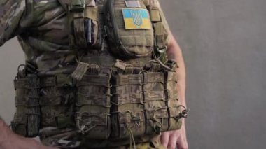 Savaş kamuflajı ve çelik yelek giyen Ukraynalı asker ceplerine şarjör doldurmuş. Ukrayna 'da Savaş.