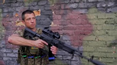 Ukraynalı asker, kamuflaj boyalı arka planda susturuculu saldırı tüfeğiyle nişan alıyor. Özel kuvvetler askeri kavramı. Ukrayna 'da Savaş.