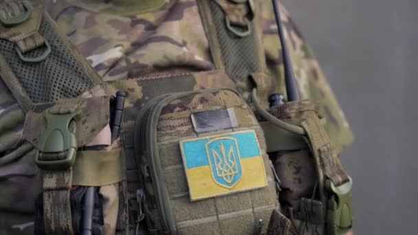 乌克兰战争中使用对讲机拍摄身穿军服 挂着乌克兰小国旗的乌克兰军人的特写镜头 — 图库视频影像