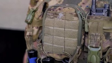 Ukraynalı askerin Ukrayna savaş üniformalı, küçük Ukrayna bayrağıyla telsiz ve Ukrayna Savaşı 'nı yakından çekerken.