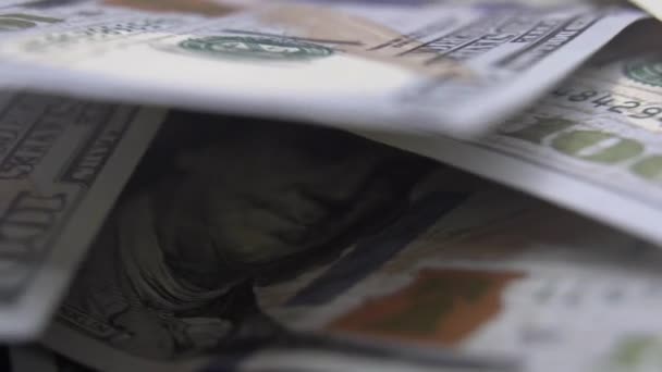 一堆堆100美元的钞票轮流散落在扇子里 新的100美元钞票在桌上旋转成一个圆圈 大量的资金 大量的现金 大量的钱 — 图库视频影像
