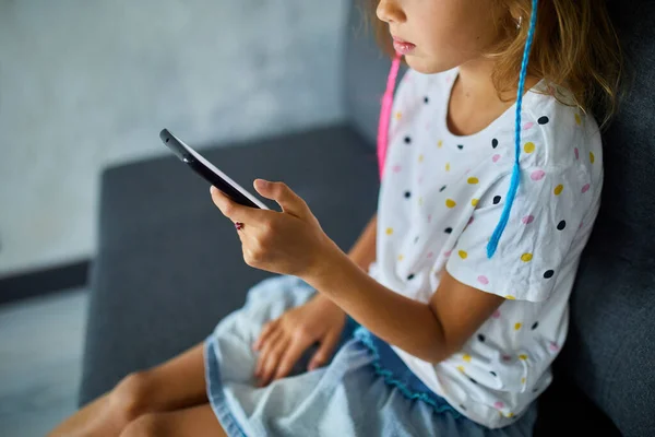 Dziecko Korzystające Telefonu Komórkowego Kanapie Nowoczesnym Jasnym Mieszkaniu Młoda Dziewczyna — Zdjęcie stockowe