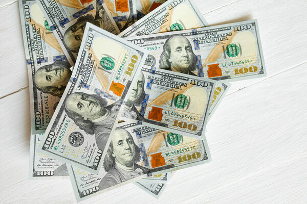 Top view flat lay of cash money american hundred dollar bills on white wooden background, Savings concept. Copy space.