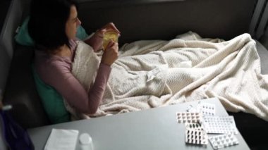 Elinde bir kupa sıcak deniz dikenli çay tutan hasta kadının ağır çekimleri.
