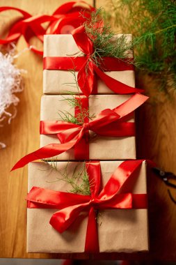 Noel çevre dostu ambalaj kağıdı ve köknar dalları Bayram sezonu için hediyeler ahşap masa üzerinde Noel, ekolojik dekor, Noel hediye kutusu